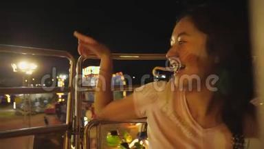在游乐园乘坐摩天轮时，亚洲女孩很<strong>兴奋</strong>。 美丽的女人在城市的高景下享受夜间<strong>狂欢</strong>节的活动。